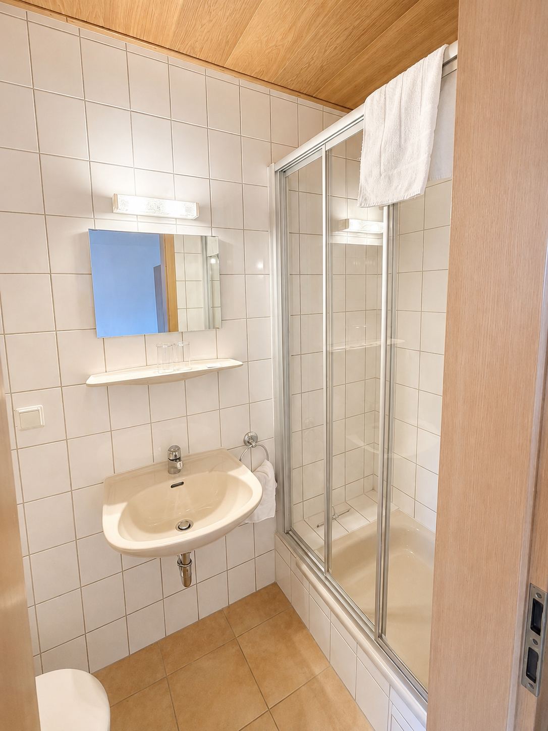Badezimmer mit Dusche in einem Zimmer mit eigenem Bad
